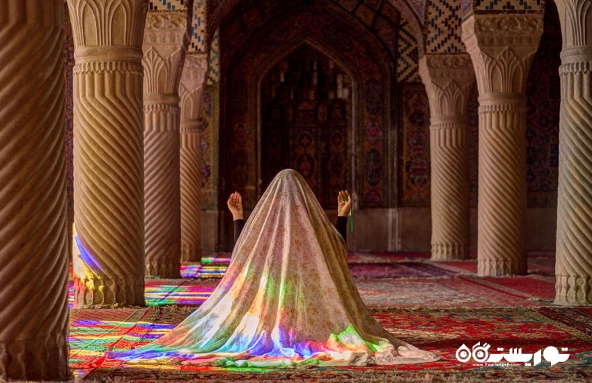 زن جوانی که در شبستان اصلی مسجد مشغول راز و نیاز است